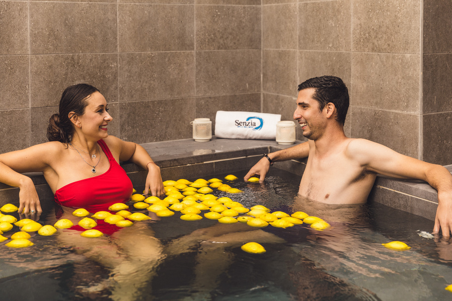 Pareja se mira en la piscina de cítricos con limones en el centro Senzia Spa & Wellness