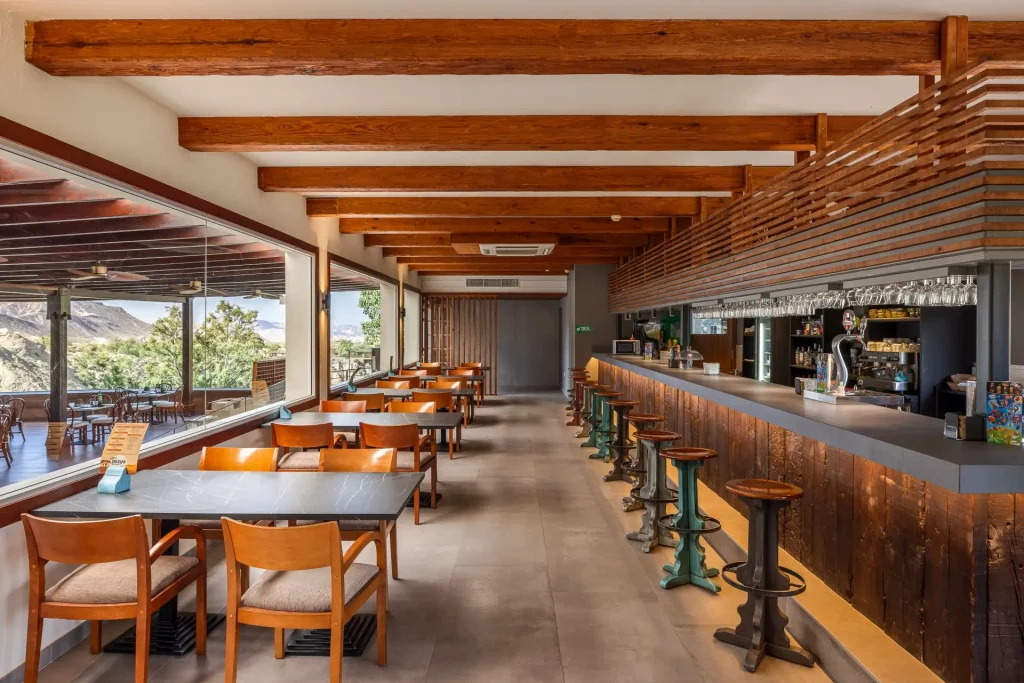 Cafetería La Reserva en MiniHollywood Oasys con mesas y barra.