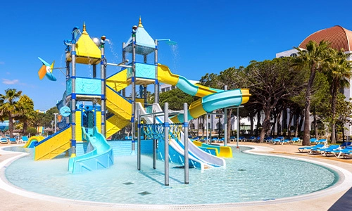 Parque acu&aacute;tico infantil con toboganes en una piscina poco profunda.