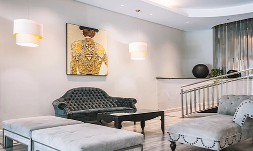 Sala moderna con sof&aacute;s grises y pintura de un torero en la pared.