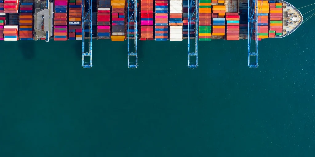 Vista a&eacute;rea de un buque portacontenedores con gr&uacute;as y contenedores de colores