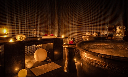 Ba&ntilde;o relajante con ba&ntilde;era, velas y toallas en un ambiente c&aacute;lido y acogedor.