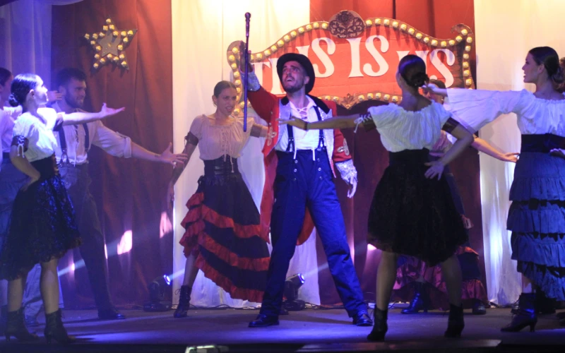 Bailarines en un escenario con luces, interpretando una coreograf&iacute;a.