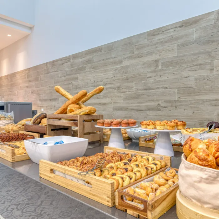 Mesa con variedad de panes y reposter&iacute;a en un buffet.