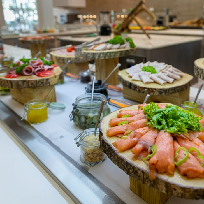 Buffet de embutidos y salm&oacute;n en rodajas sobre platos de madera.