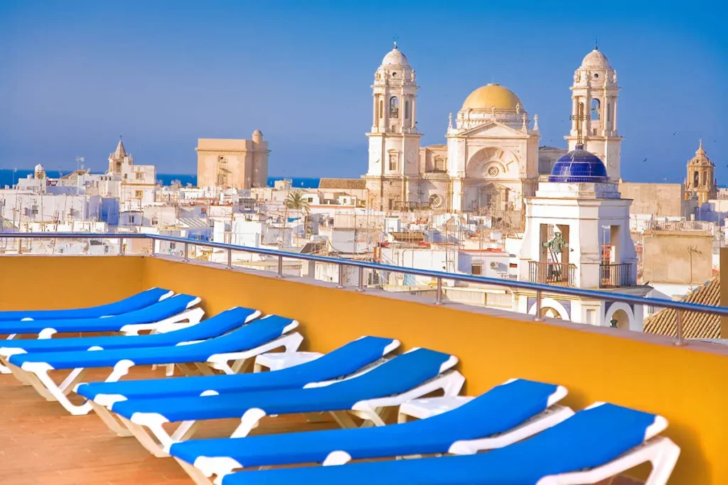 Vista de la terraza con bungalows y catedral de fondo en C&aacute;diz, Espa&ntilde;a