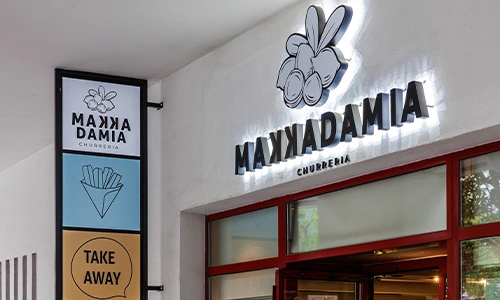 Letrero de churro stand "Maxkadamia" con opci&oacute;n para llevar.