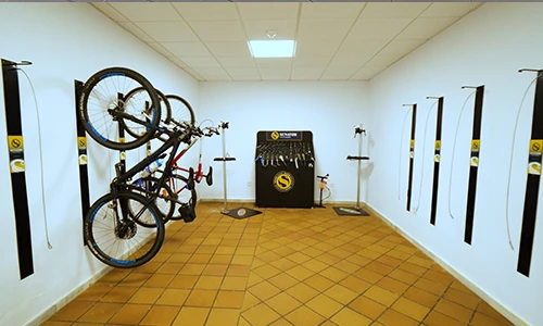 Estacionamiento de bicicletas en interior con bicicletas colgadas en la pared.