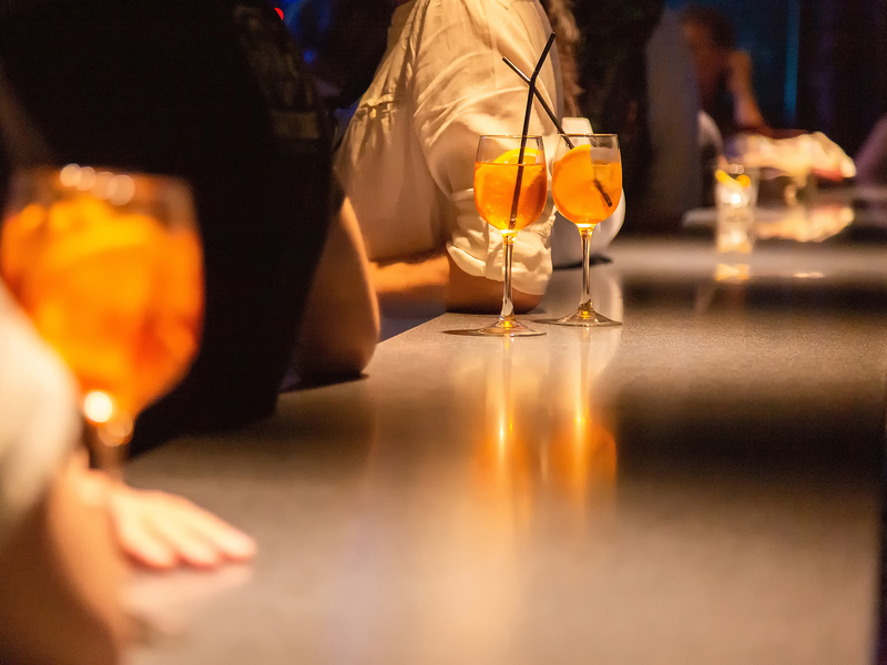 A glasses of alcoholic cocktail with orange at the bar.