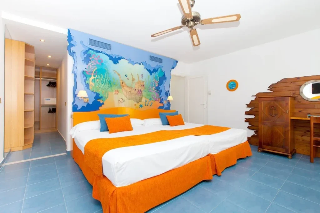 Dormitorio moderno con cama naranja, mural mapa y ventilador de techo