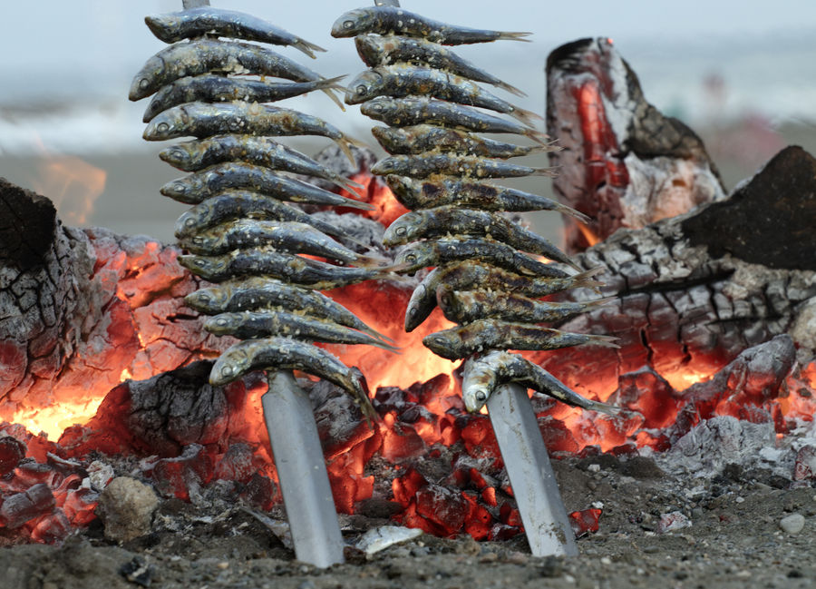Espetos en playa con las ascuas de fondo