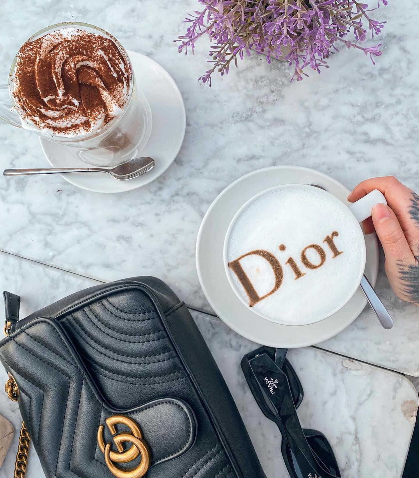 Fotografía de una mesa, con cafés junto con un bolso y flores