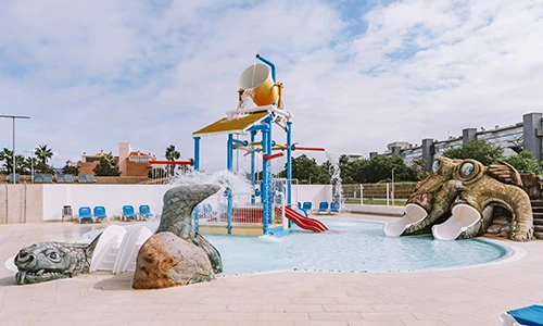 &Aacute;rea de juegos acu&aacute;ticos con toboganes y figuras de animales en una piscina.