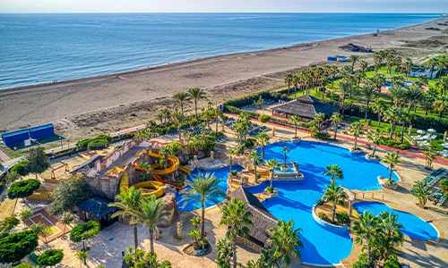 Parque acu&aacute;tico junto a una amplia playa y el mar.