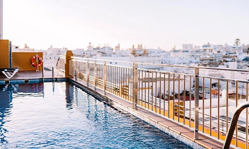 Piscina en la azotea con una vista panor&aacute;mica de la ciudad al atardecer.