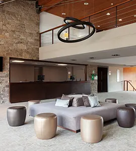 Sala moderna con sillones y mesa circular en interior con l&aacute;mpara colgante