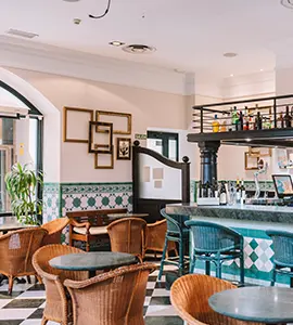Sala de bar interior con sillas de mimbre y decoraci&oacute;n moderna