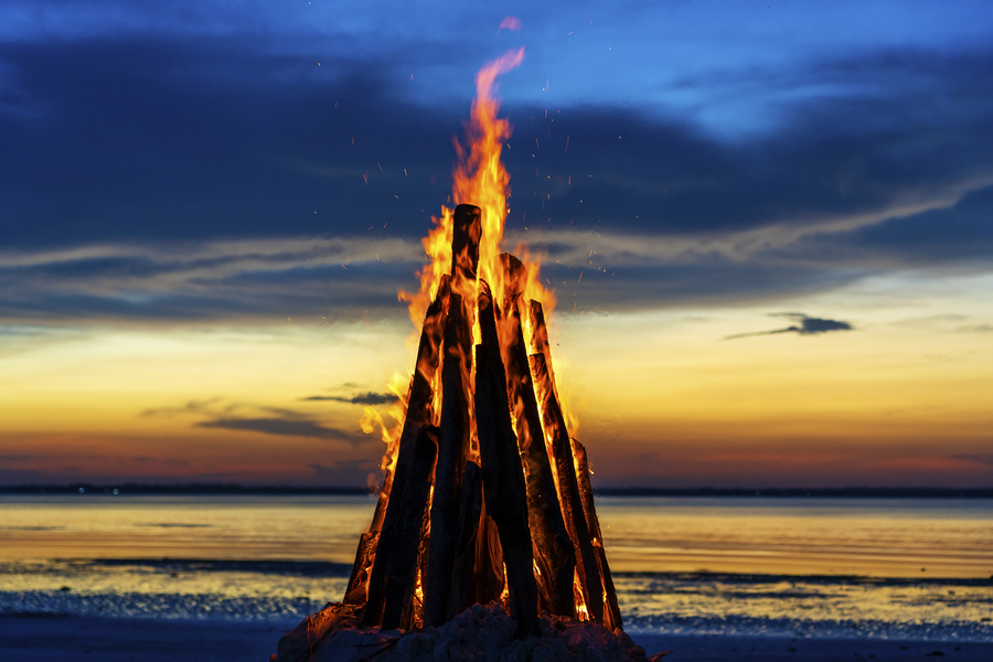 Hogueras de San Juan. The big fire burns against the background of the night sky near sea on the island of Zanzibar, Tanzania, East Africa, close up. Bright flame. A bonfire in the evening.