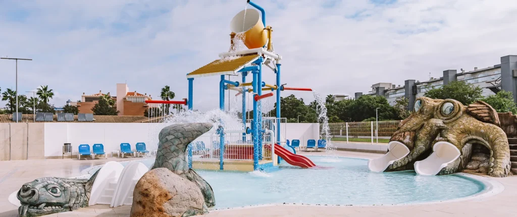 Piscina infantil con surtidor y tobog&aacute;n, figura de tortuga en el borde