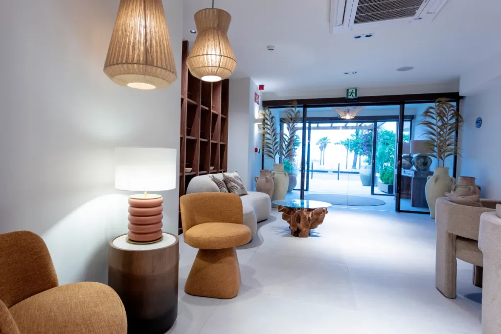 Sala moderna con sillones, l&aacute;mparas de madera y acceso a jard&iacute;n exterior
