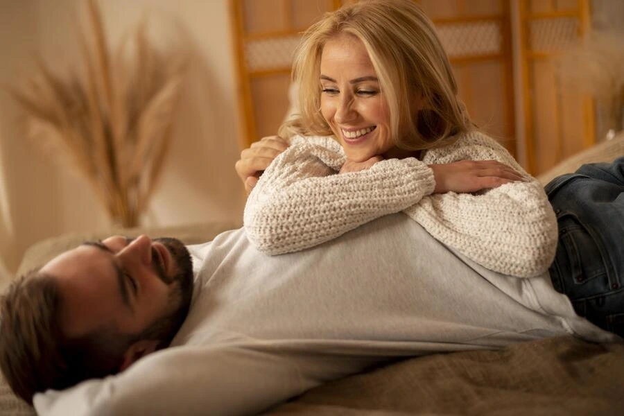 Pareja mirándose el uno al otro con complicidad en una habitacion de hotel