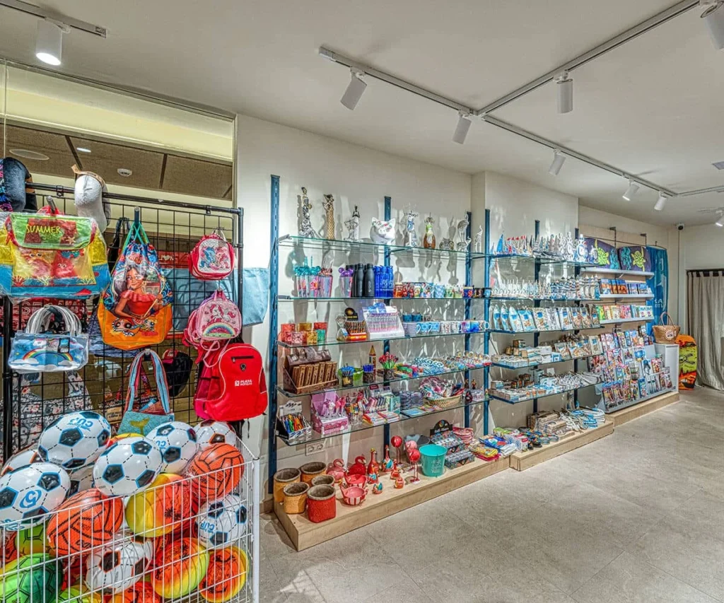 Tienda de souvenirs con mochilas, pelotas y estantes de productos infantiles.