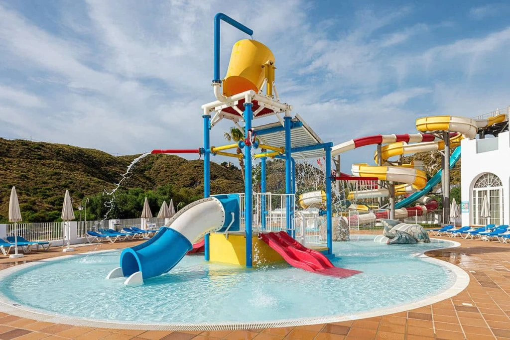 Parque acuático con toboganes y piscina azul al aire libre bajo el cielo.