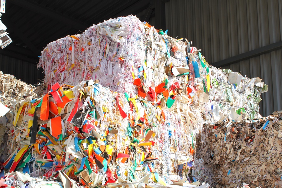 Bloque de papel reciclado con papeles de colores en una central de reciclaje de deshechos