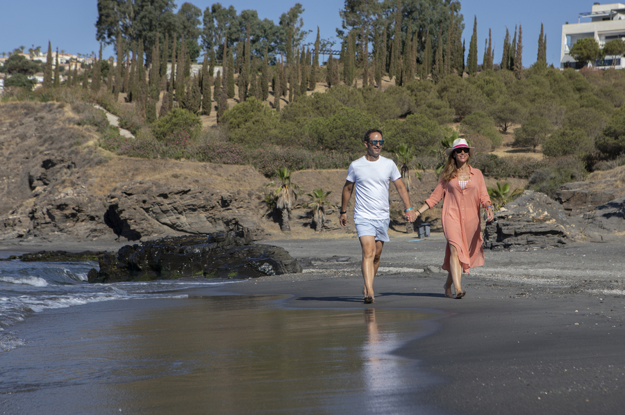 Pareja de la mano caminando por la orilla de la playa de Almuñécar