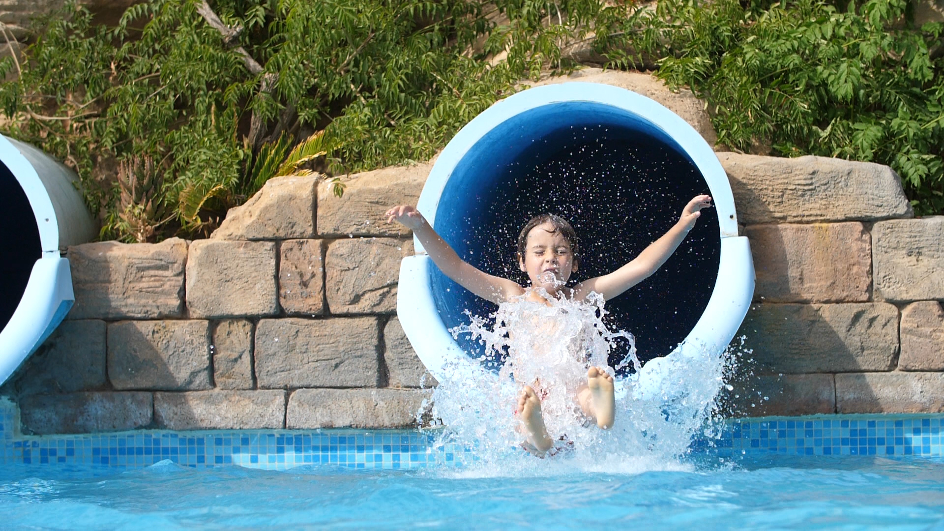 Niño tirándose por tobogán en la piscina de Minihollywood Oasys