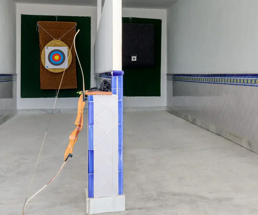 Estaci&oacute;n de tiro con blanco circular, mesa y cables en un pabell&oacute;n de tiro