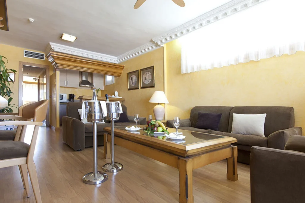 Sala de estar moderna con sof&aacute;, mesa y elementos decorativos en hotel