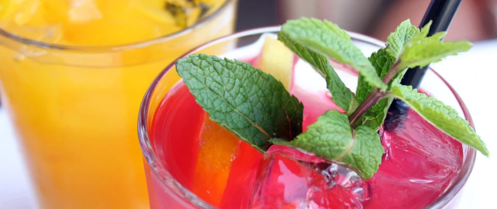 Bebida con hielo y hojas de menta en un vaso de colores