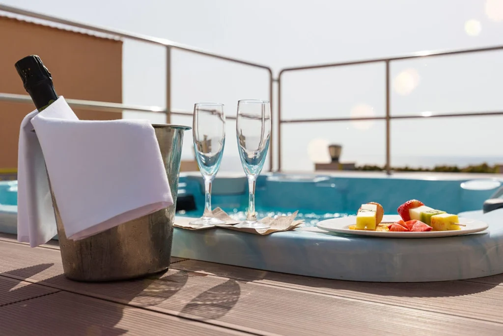 Mesa con cubitera, copas y bandeja de frutas junto a la piscina