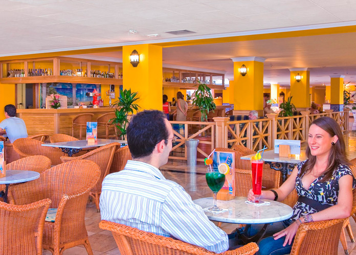 Pareja disfrutando de un refrigerio en la cafetería del Playaluna Hotel