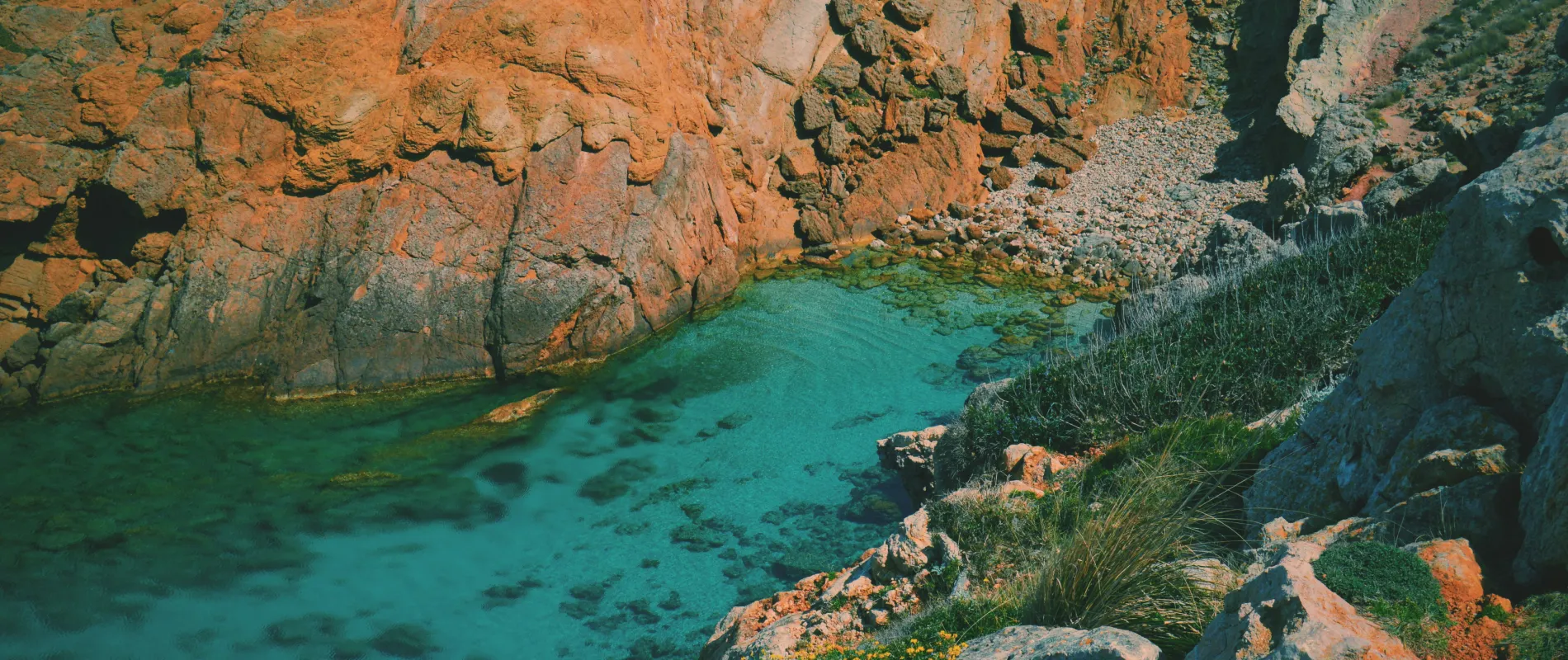 Cascada y aguas turquesas junto a acantilados rocosos en un ca&ntilde;&oacute;n &aacute;rido
