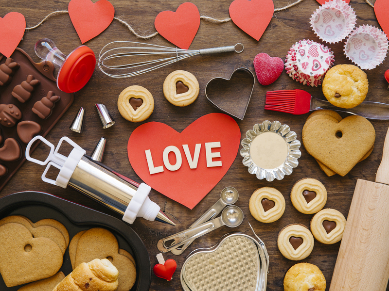 Reposteria de San Valentín con moldes y galletas con forma de corazón y tonos rojos