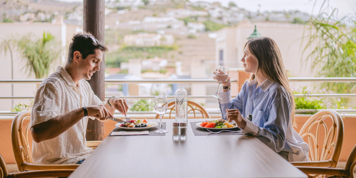 Pareja disfrutando de una comida en la terraza.
