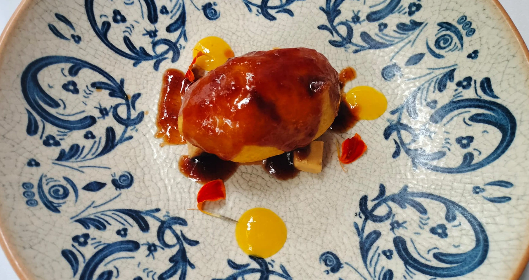 Plato decorado con un platillo gourmet y salsas de colores.