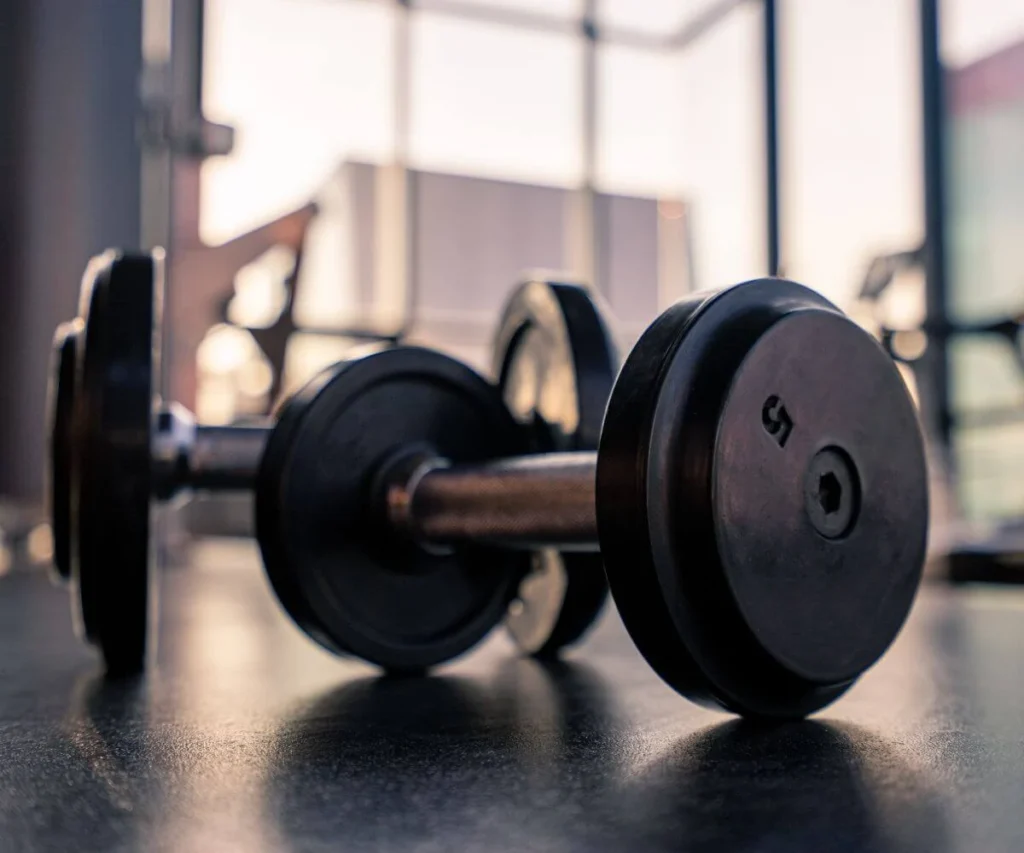 Barra con discos de pesas en un gimnasio, enfoque en la barra con plato negro