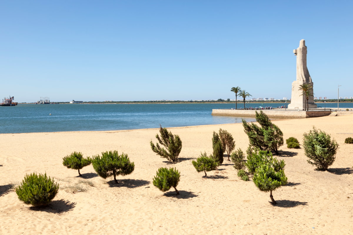 Monumento a Col&oacute;n en Huelva con playa de fondo en Huelva