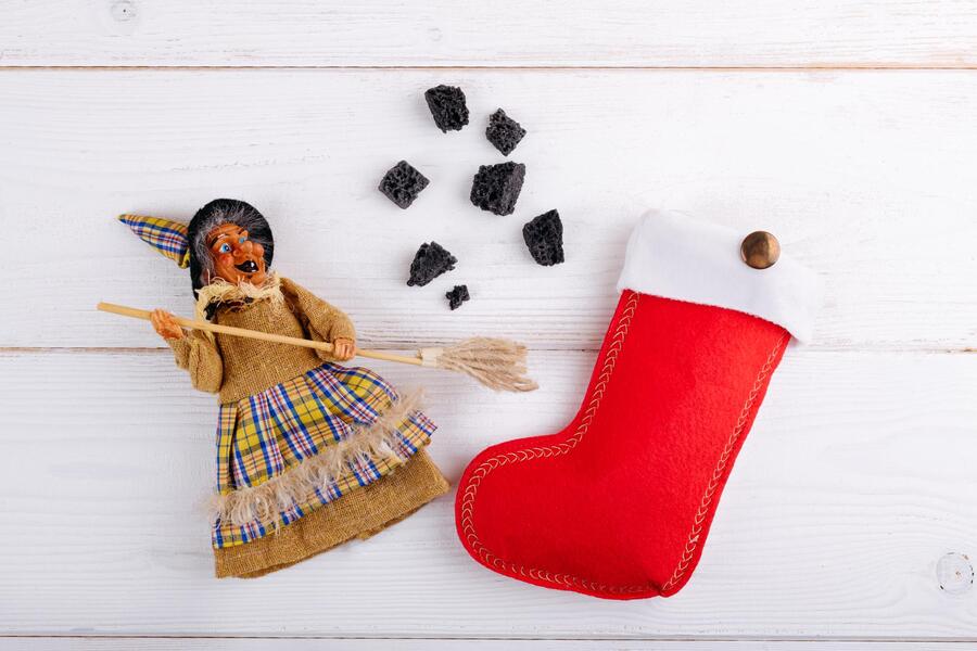 witch-befana-red-stocking-with-sweet-coal-candy-white-wooden-background-italian-epiphany-day-tradition
