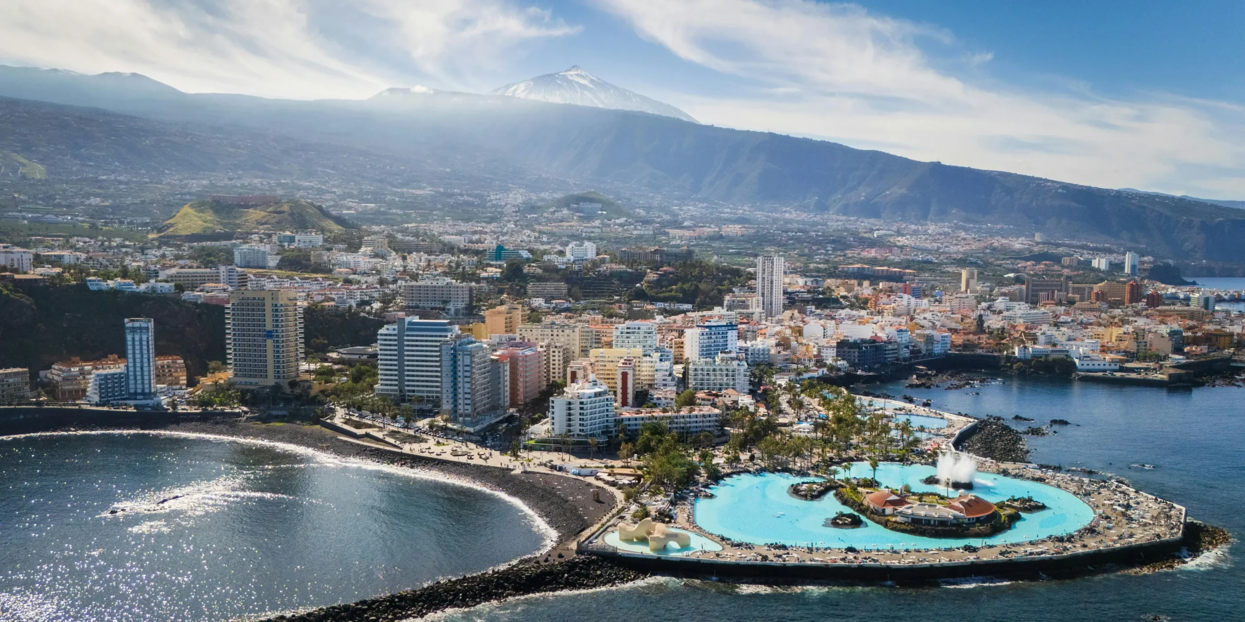 Vista aérea del Puerto de la Cruz con el complejo Martiánez y el Teide al fondo.