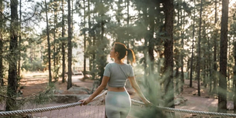 Mujer de espaldas disfrutando de la naturaleza y el bosque de pinos en Hotel Villalba.