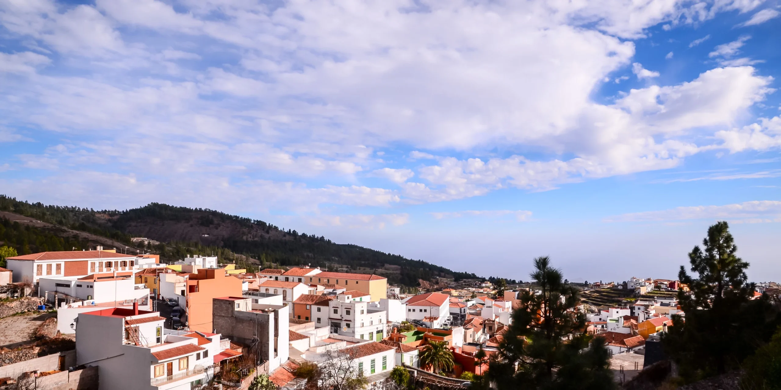 Panorámica del pueblo de Vilaflor de Chasna rodeado de pinares bajo un cielo azul.