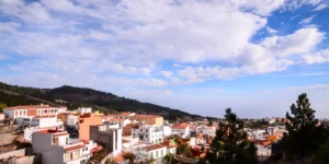 Panoramic view of picturesque mountain village with white houses and orange tile roofs in Tenerife under a blue sky, perfect for a quiet midweek getaway.